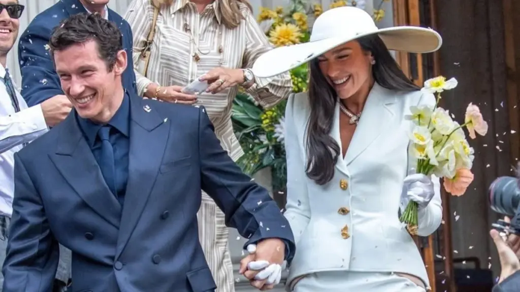 Dua Lipa wearing bespoke ivory Schiaparelli couture skirt suit with gold buttons at her London wedding 2026